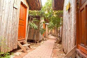 an alley with an old building and a wooden fence at Bayrams Tree Houses in Olympos