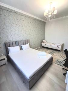 a bedroom with a large white bed and a desk at #52 Просторная 3 комнатная квартира in Atyraū