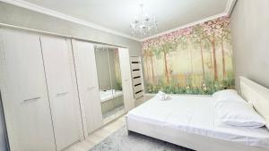 a bedroom with a bed and a large window at #52 Просторная 3 комнатная квартира in Atyraū