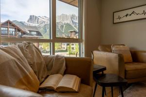 a living room with a couch with an open book at Modern Mountain Oasis Top floor 2 level 2bd in Canmore