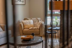 a living room with a chair and a table at Modern Mountain Oasis Top floor 2 level 2bd in Canmore