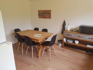a dining room table with chairs and a television at Central Studio in Billund - 500 m from LegoHouse in Billund