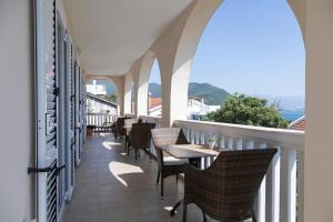 a balcony with chairs and tables and a view of the ocean at Vila Midami - Herceg Novi Savina in Herceg-Novi