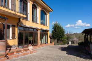 a yellow building with a walkway in front of it at Sorriso Dei Maestri in Calosso