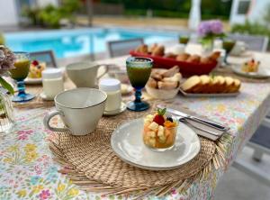 a table with a plate of food and drinks on it at La Musardise Guest House in Berson