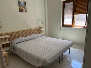 a bed in a white room with a window at Casa Mare Verde in Casamicciola Terme