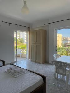 a bedroom with a bed and a table and chairs at Marina Apartaments in Himare