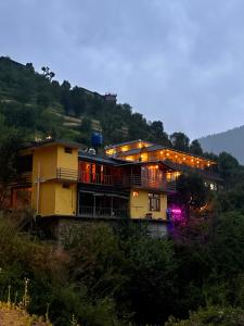 ein Haus auf einem Hügel mit Lichtern in der Unterkunft Zoella in Gushaini