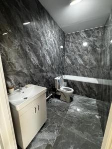 a bathroom with a sink and a toilet at Уют студия in Astana