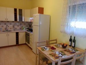 a kitchen with a table and a white refrigerator at Apartment Sofia in Sutomore