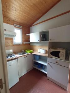 滨海苏拉克Camping Les Oyats的小厨房配有白色橱柜和微波炉 更多13张照片