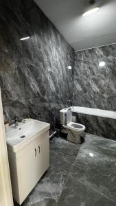 a bathroom with a sink and a toilet at Уют студия in Astana