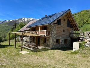 a large log cabin with a porch and a deck at Chalet d'alpage " L'Estive " in Saint-Sorlin-dʼArves