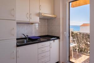 a kitchen with a sink and a view of the ocean at Yellow house apartments in Podstrana