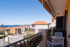 a balcony with a table and chairs and a view of a street at Yellow house apartments in Podstrana