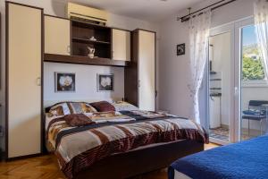 a bedroom with a large bed and a large window at Yellow house apartments in Podstrana