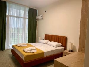 a bedroom with a bed with two towels on it at Hotel Aeetes Kobuleti in Kobuleti