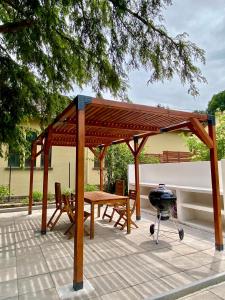 a wooden pavilion with a table and a grill at La Villa Hortensia in Jungholtz