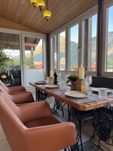 a dining room with a table and chairs and windows at wolke 7, Alpenblick mit Eleganz, Kingsizebett, Kamin, Terrasse mit Grill, Garten in Kiefersfelden