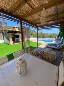 a patio with a table and chairs and a pool at AMIRA home near Sitges in Sant Pere de Ribes