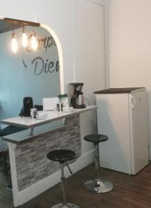 トロワにあるLE KLEBER au choix VUE SUR PARC ou RUE simplicité d'accès, charme et confort garantisの冷蔵庫のある部屋には2脚の椅子が置かれたカウンターがある