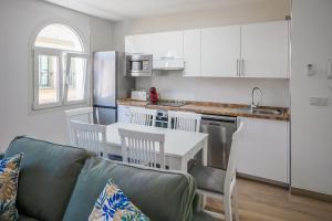 a living room with a couch and a table and a kitchen at Apartamento centro ciudad patio cuarenta 2A in Algeciras