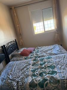 a bed sitting in a bedroom with a window at Appartement FNIDEQ BAB CEUTA in Fnidek +4 photos