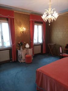 a room with red curtains and two tables and a chandelier at Suite in The Calm Nature of Prosecco Valley in Revine Lago