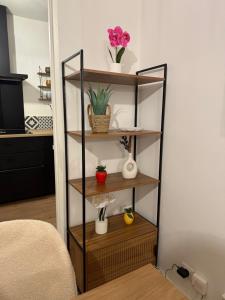 a shelf with flowers and vases on it in a room at Appartement 50m2, résidence privée avec piscine, tennis et à 100 m de la plage in Le Lavandou +9 photos