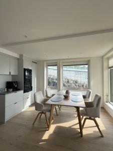 a kitchen and dining room with a table and chairs at NORDIQ by the Fjord in Spro