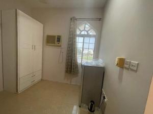 a white room with a window and a refrigerator at غرفه بحمام خاص in Muscat