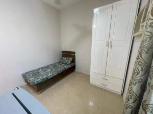 a small room with a bed and a white cabinet at غرفه بحمام خاص in Muscat