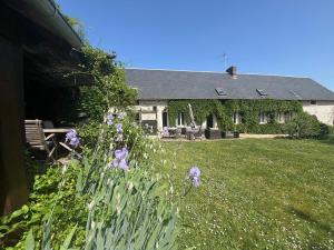 una casa con fiori viola di fronte a un cortile di Normandy Cottage, sports and relaxation a Fontaine-sous-Jouy