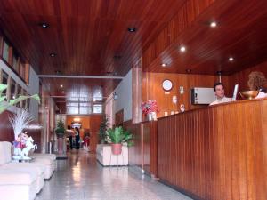 a man standing at a counter in a lobby at Hotel Melodia in Lima