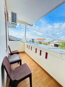 a balcony with two chairs and a window at Homestay Room near Kuta & Legian Beach Bali in Pesanggaran