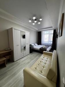 a living room with a couch and a bed at Уют студия in Astana