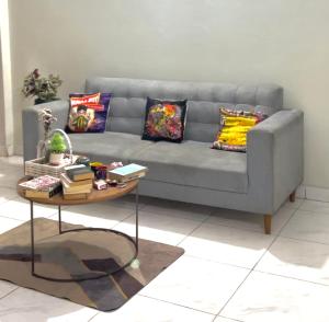 a living room with a gray couch and a table at Apna Adda for ladies only in Karachi