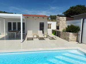a patio with a pool and chairs and a house at Villa Velim - Stunning view & Heated private pool in Stankovci