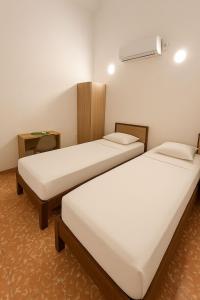 a room with two beds and a fan at SGH Hotel San Agustin in Santa Marta