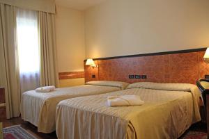 A bed or beds in a room at Park Hotel Villa Leon d'Oro