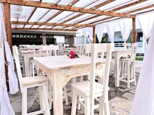 a wooden table and chairs under a pergola at Villa SunShine exclusive in Watamu