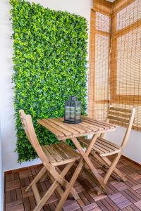 a wooden table and chairs in front of a green wall at Casa do Parque in Lagos