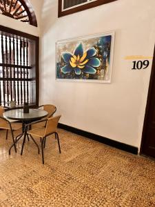 a dining room with a table and chairs and a painting at SGH Hotel San Agustin in Santa Marta