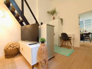 une pièce avec un bureau et une table avec un vase dans l'établissement Appartement de charme 2ch centre historique, WIFI, à Montpellier