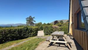 a picnic table sitting on the side of a house at 1 Bedroom Cabin with Mountain & Loch Views - Quiet Location between Glencoe & Ben Nevis in Corran