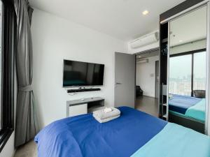 a bedroom with a blue bed and a flat screen tv at The base central Pattay CD in Pattaya Central +46 photos