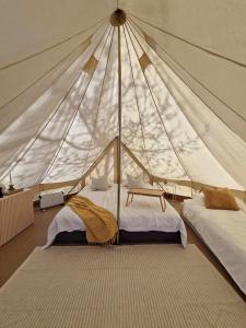 a bedroom with two beds in a tent at Bergs Slussar Glamping in Vreta Kloster