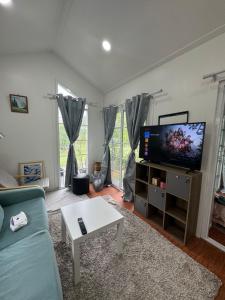 a living room with a couch and a flat screen tv at Good life home in U Tapao