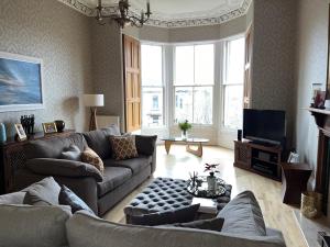 a living room with two couches and a television at Quiet room in vibrant Bruntsfield with private parking in Edinburgh