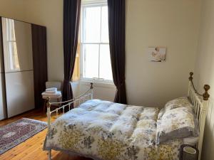 a bed in a bedroom with a window and a bedspread at Quiet room in vibrant Bruntsfield with private parking in Edinburgh